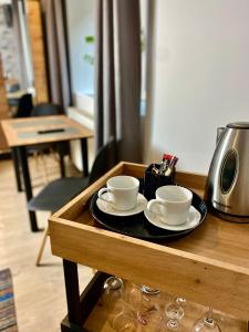 two coffee cups and saucers on a wooden table at Old Tree Home & Restaurant in Oświęcim