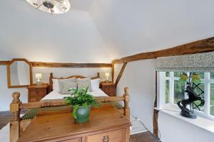 um quarto com uma cama e uma mesa com uma planta em Charming, dog friendly cottage em Doddington