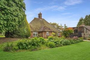 uma casa velha com um jardim de relva em frente em Charming, dog friendly cottage em Doddington