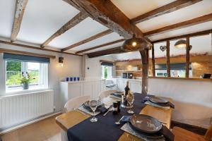 a dining room with a table and chairs and a kitchen at Charming, dog friendly cottage in Doddington