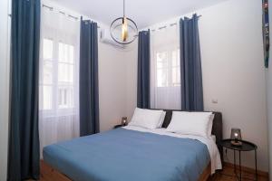 a bedroom with a blue bed with blue curtains at Casa nella Fortezza in Corfu Town