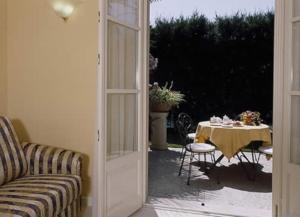 una porta che si apre su un patio con tavolo, tavolo e sedie di Hotel Villa Delle Palme a Cannobio