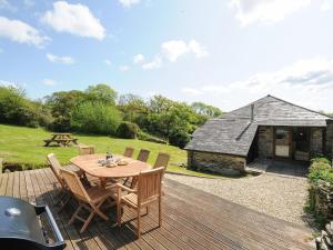 a wooden deck with a table and chairs and a building at Mill House in Lostwithiel