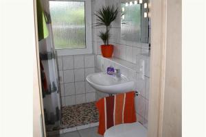 a white bathroom with a sink and a toilet at Dogge, Ferienwohnung in Celle
