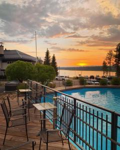 a deck with tables and chairs next to a swimming pool at Aateli Lakeside Chalets - former Vuokatti Suites in Vuokatti