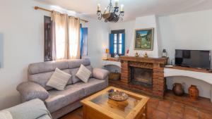 salon z kanapą i kominkiem w obiekcie Villa Azul de Frigiliana by Ruralidays w mieście Frigiliana