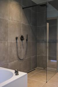 ein Bad mit einer Dusche und einem Waschbecken in der Unterkunft Gasthuis Veurne in Veurne