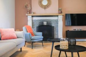 a living room with a couch and a fireplace at Gasthuis Veurne in Veurne