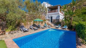 basen z krzesłami i parasolem obok domu w obiekcie Villa Azul de Frigiliana by Ruralidays w mieście Frigiliana