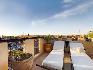 d'un balcon avec deux bancs blancs sur le toit. dans l'établissement DAR AL AMAL, à Marrakech
