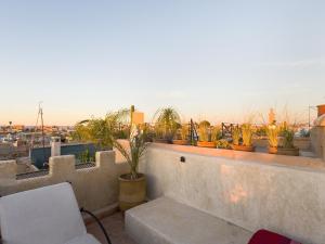 - un balcon avec des plantes en pot au-dessus d'un bâtiment dans l'établissement DAR AL AMAL, à Marrakech