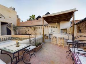 a patio with tables and chairs and a kitchen at DAR AL AMAL in Marrakesh