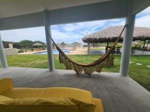 eine Hängematte auf einer Veranda mit Pool in der Unterkunft Cabanas da Sorte in Fortim