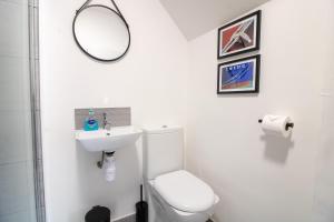 a bathroom with a toilet and a sink and a mirror at No.89 Stylish Ground Floor Apartment in Paignton +10 photos