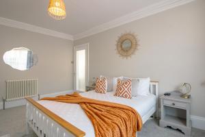 a bedroom with a bed with an orange blanket on it at No.89 Stylish Ground Floor Apartment in Paignton