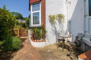 een patio met een tafel en stoelen voor een huis bij No.89 Stylish Ground Floor Apartment in Paignton