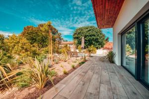 une passerelle en bois menant à une arrière-cour ornée de plantes dans l'établissement Villa luxe Oasis de Satteva, à LʼIsle-sur-la-Sorgue