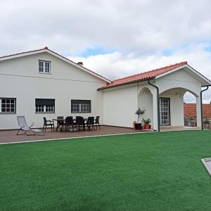 ein weißes Haus mit grünem Rasen in der Unterkunft Casa do Espinheiro in São Mamede