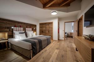 1 dormitorio con 1 cama grande y pared de madera en Hotel Franks, en Oberstdorf