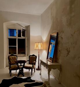 a living room with a mirror and a table and chairs at Csaky Palace Bratislava in Bratislava