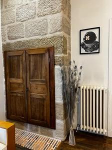 a room with a wooden door next to a brick wall at #Le Vasco - Grand F2 avec Terrasse - Hyper Centre in Brive-la-Gaillarde