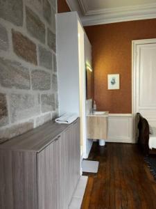 La salle de bains est pourvue d'un lavabo et d'un mur en pierre. dans l'établissement #Le Vasco - Grand F2 avec Terrasse - Hyper Centre, à Brive-la-Gaillarde