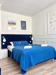 1 dormitorio con 1 cama azul con sábanas azules en Smart Apartment Ustronie Morskie en Ustronie Morskie