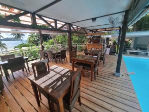 a deck with tables and chairs next to a swimming pool at Ocean View Apartment in Praslin