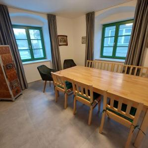 a dining room with a wooden table and chairs at Apartmány Phlora in Lysice