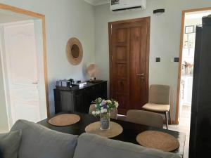 a living room with a couch and a table with flowers at Kivulini House - close to the beach in Dar es Salaam