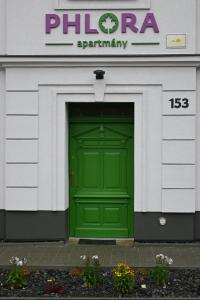 a green door in the front of a building at Apartmány Phlora in Lysice
