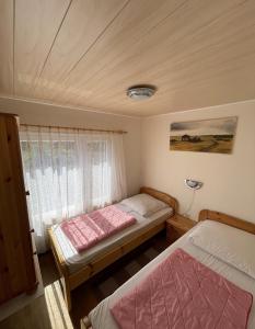 a bedroom with two beds and a window at Gemütlicher Bungalow an der Mecklenburgischen Seenplatte in Jabel