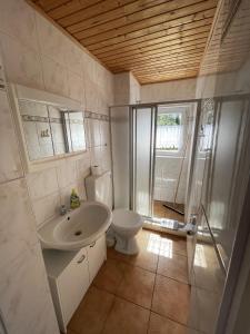 ein Bad mit einem Waschbecken und einem WC in der Unterkunft Gemütlicher Bungalow an der Mecklenburgischen Seenplatte in Jabel