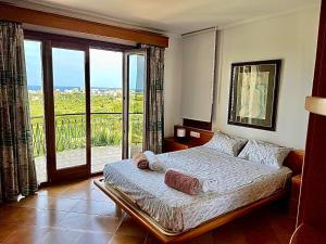um quarto com uma cama e uma varanda com vista em Finca Na Penyal em Cala Bona