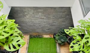 a room with green plants and a brick wall at Siro homestay in Danang