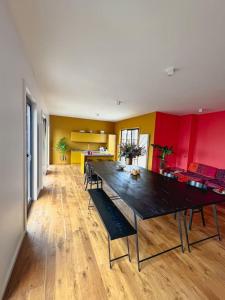 uma sala de jantar com uma grande mesa preta e paredes vermelhas em Laila Penthouse em Antuérpia