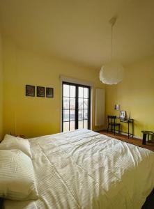 Un dormitorio con una gran cama blanca y una ventana en Laila Penthouse en Amberes