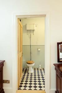 a bathroom with a toilet and a checkered floor at Kings Arms Hotel in Bicester