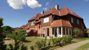 a large house with brown roof at Petersdorf Ferienwohnung Lucky in Westfehmarn