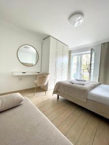 a bedroom with a bed and a mirror and a chair at Smart Apartment Ustronie Morskie in Ustronie Morskie