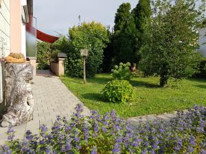 einen Garten mit lila Blumen neben einem Haus in der Unterkunft Ferienhaus Jutta am Bodensee in Uhldingen-Mühlhofen