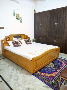 a wooden bed sitting on a rug in a bedroom at Kridha holidays homestay with kitchen in Vrindāvan