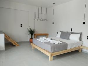 a white bedroom with a bed with a wooden frame at Zorbas in Sougia