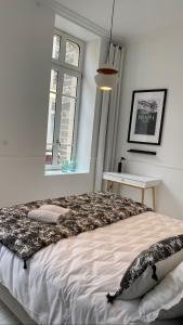 um quarto com uma cama grande e uma janela em N9 APPARTEMENT DE CHARME **** MORLAIX em Morlaix