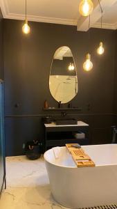 a bathroom with a tub and a large mirror at N9 APPARTEMENT DE CHARME **** MORLAIX in Morlaix