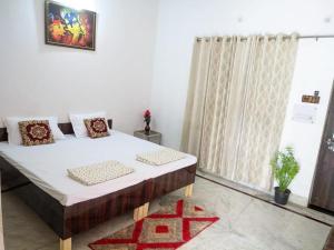 a bedroom with a large bed and a window at Kridha holidays homestay with kitchen in Vrindāvan