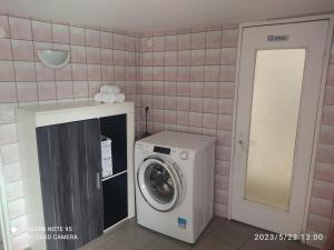 - une buanderie avec un lave-linge et un miroir dans l'établissement Au Bon Vieux Port Maison de vacances Alsacienne à 10mn de Ribeauvillé, Riquewihr et Kaysersberg, à Sélestat