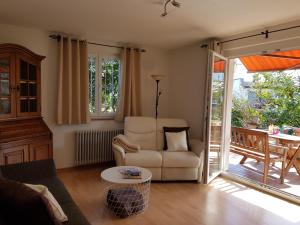 ein Wohnzimmer mit einem Sofa, einem Stuhl und einem Tisch in der Unterkunft Ferienhaus Jutta am Bodensee in Uhldingen-Mühlhofen
