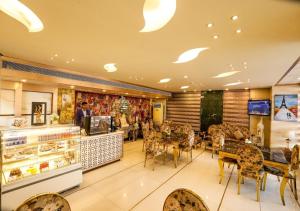 a restaurant with tables and chairs and a counter at HK Clarks Inn, Amritsar in Amritsar