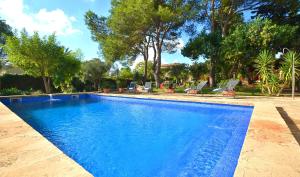 una piscina en un patio con sillas y árboles en Villa Cas Cosinet by PriorityVillas, en Consell
